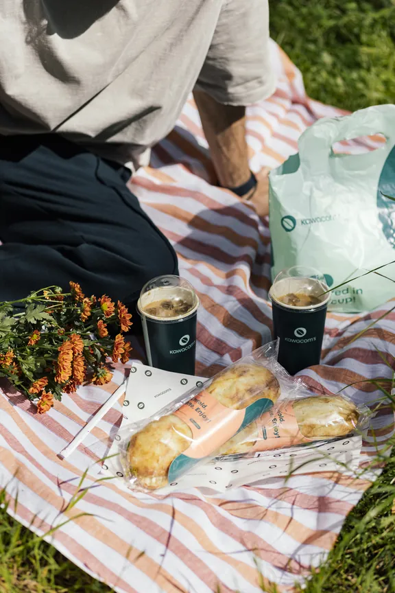Picnic blanket with sandwiches and iced Kawacom's coffees