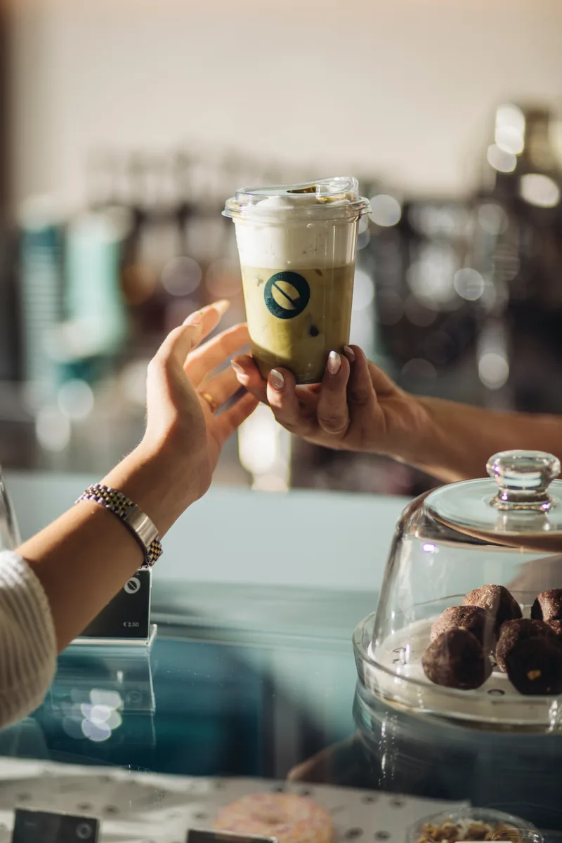 Friends toasting with cappuccinos at a café table