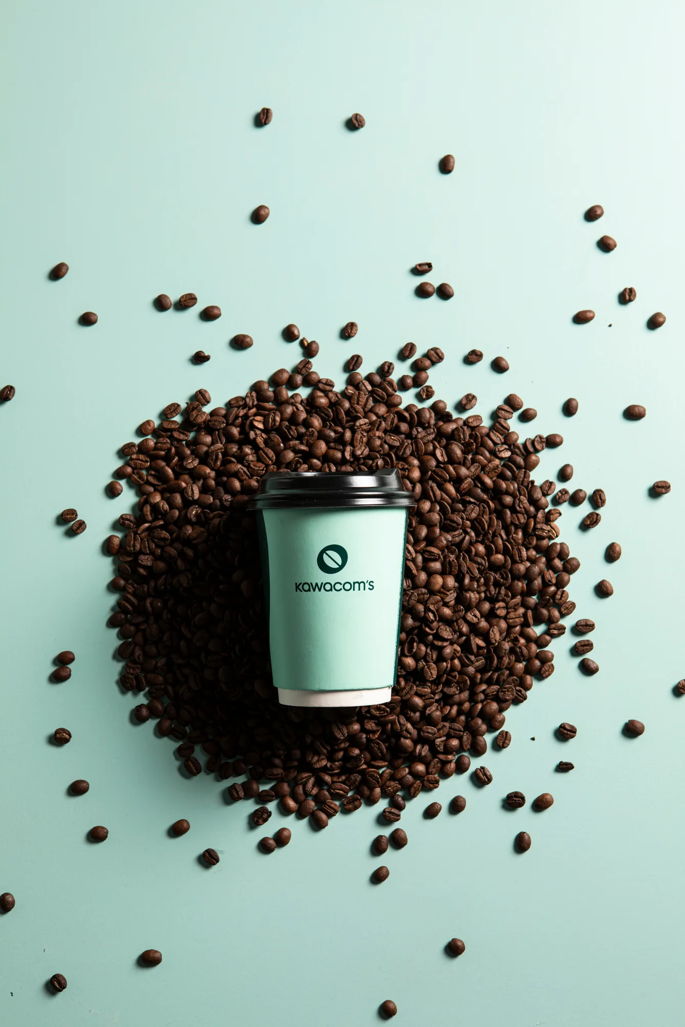 Coffee cup surrounded by roasted Arabica beans